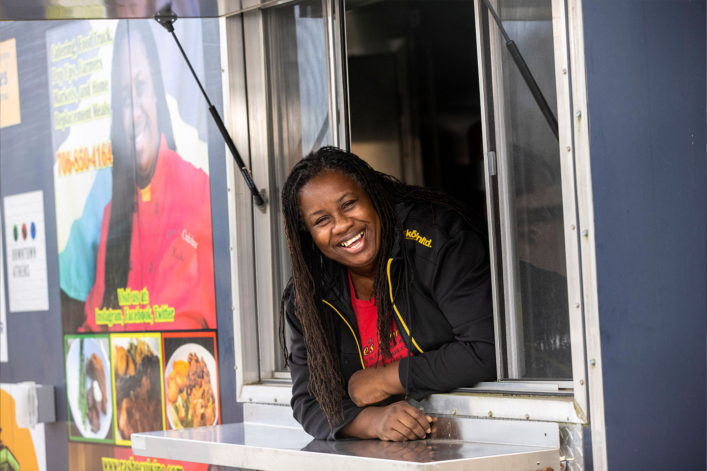 small business owner smiling out of the food truck window