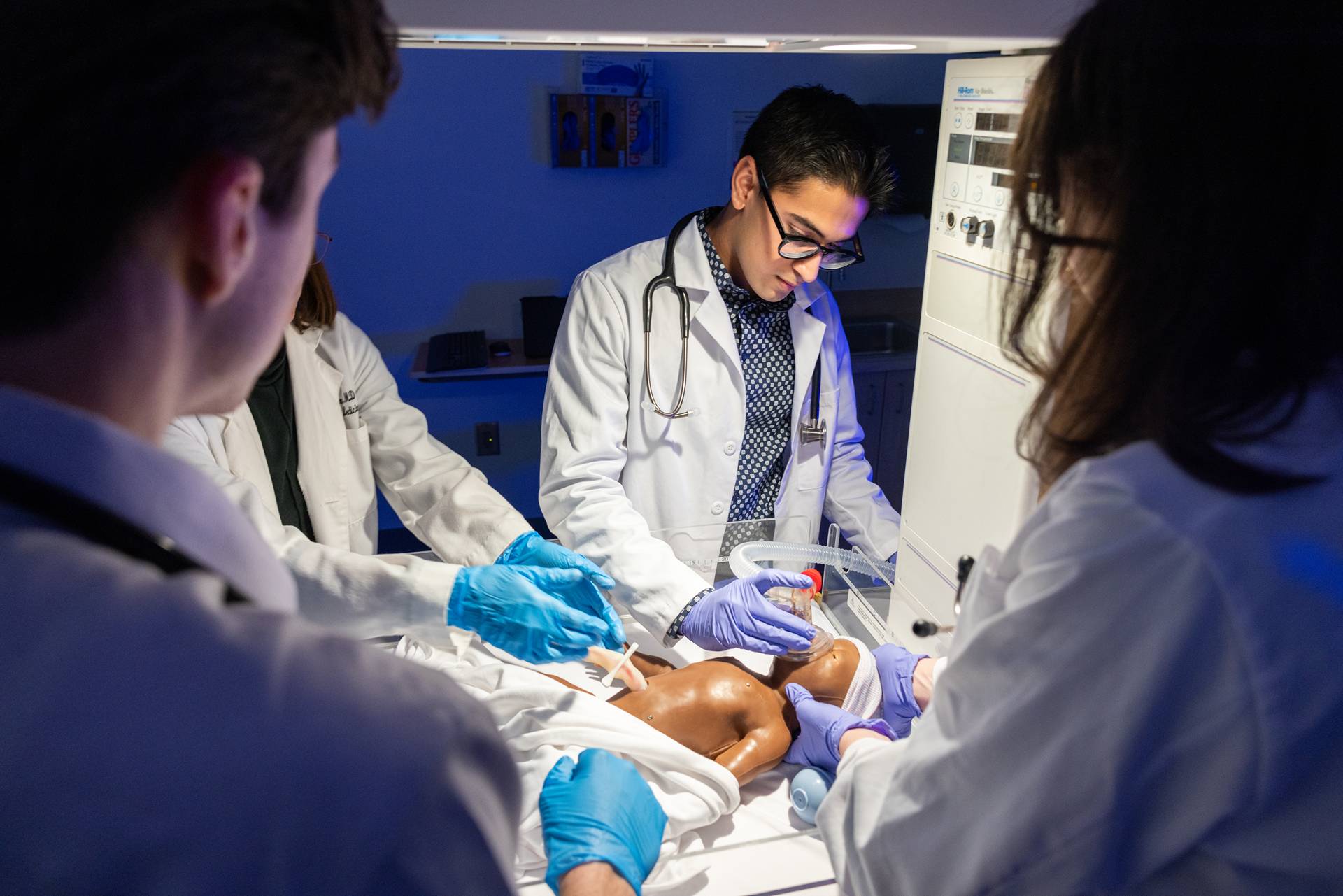 A closeup of Dr. Aimee Martin and medical student Suraj Modi training with an infant patient simulator.