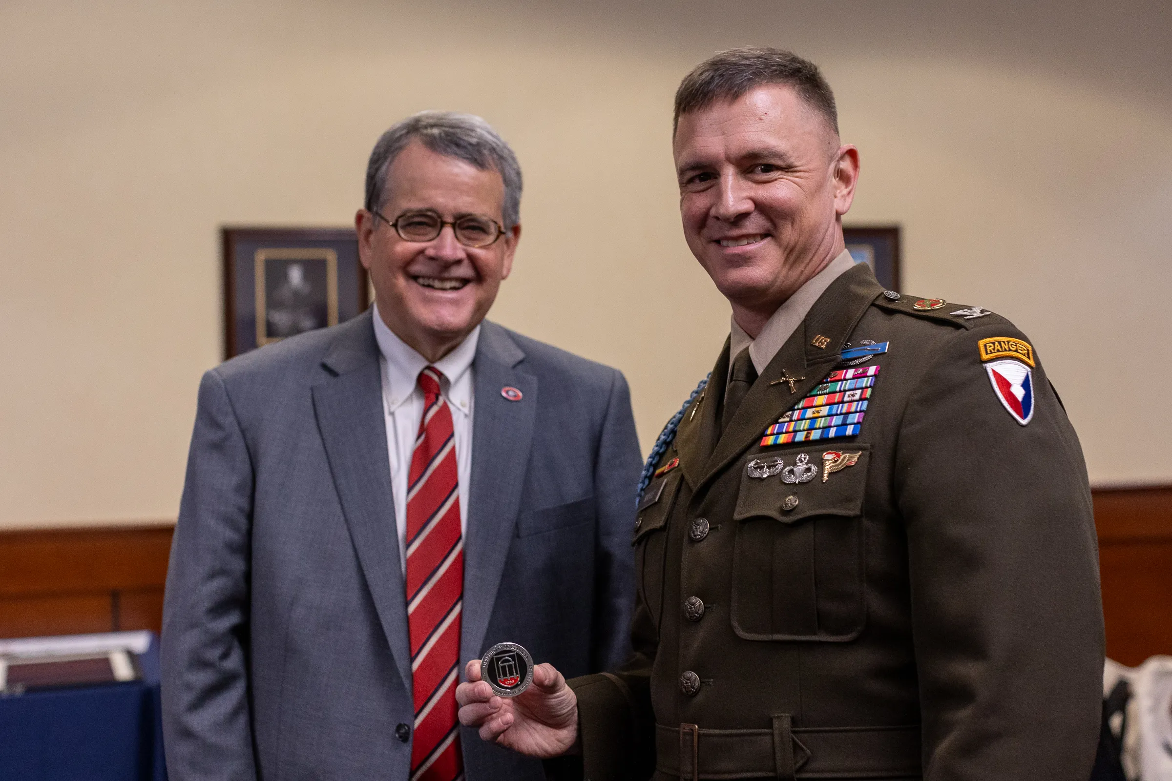 UGA President Jere W. Morehead with military representative showing a “challenge coin” given after signing the proclamation.