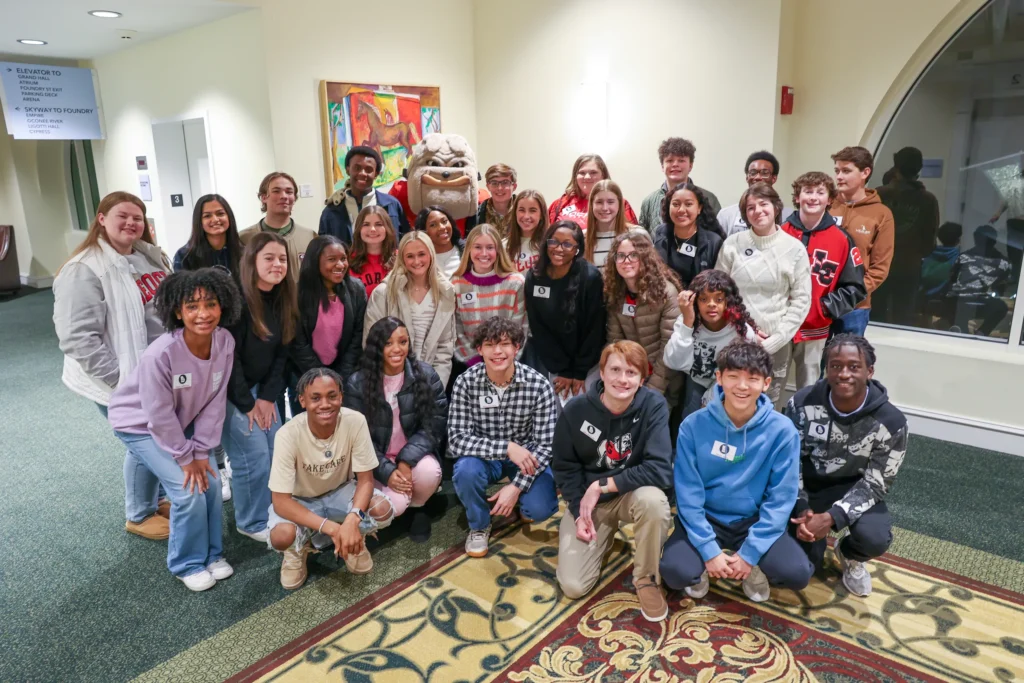 A group photo of several students from the Youth Lead Georgia Program posing with the University of Georgia's mascot, Hairy Dawg.