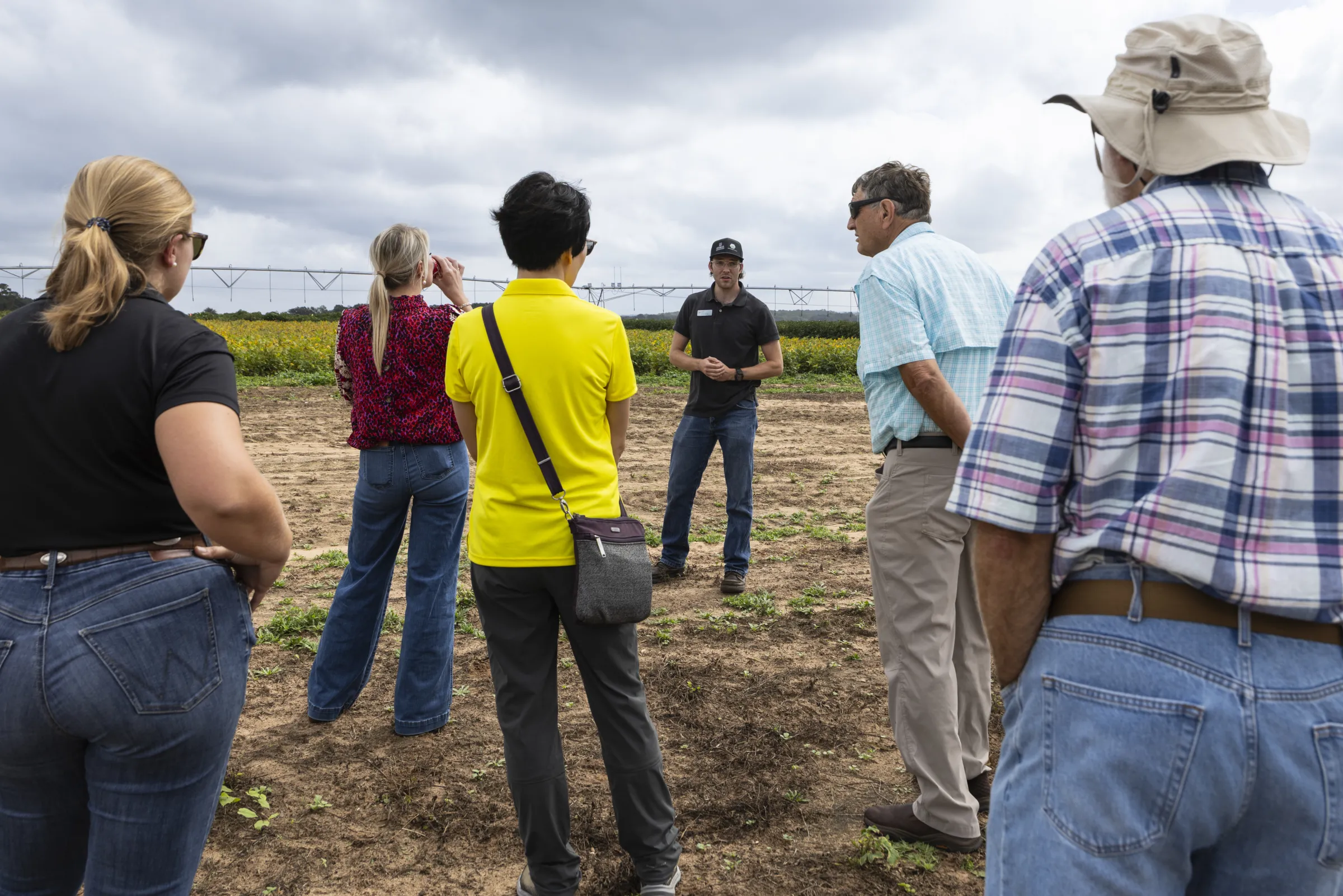 A man wearing a black polo and jeans leads a tour at the UGA Grand Farm in Perry.